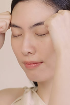 눈을 감고 이마를 부드럽게 마사지하는 여성의 모습은 설화수 진설크림 리치의 풍부한 영양과 탄력있는 피부를 연출하는 효과를 보여줍니다.